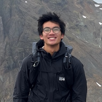 Thai Villaluna smiling outdoors in front of a mountain